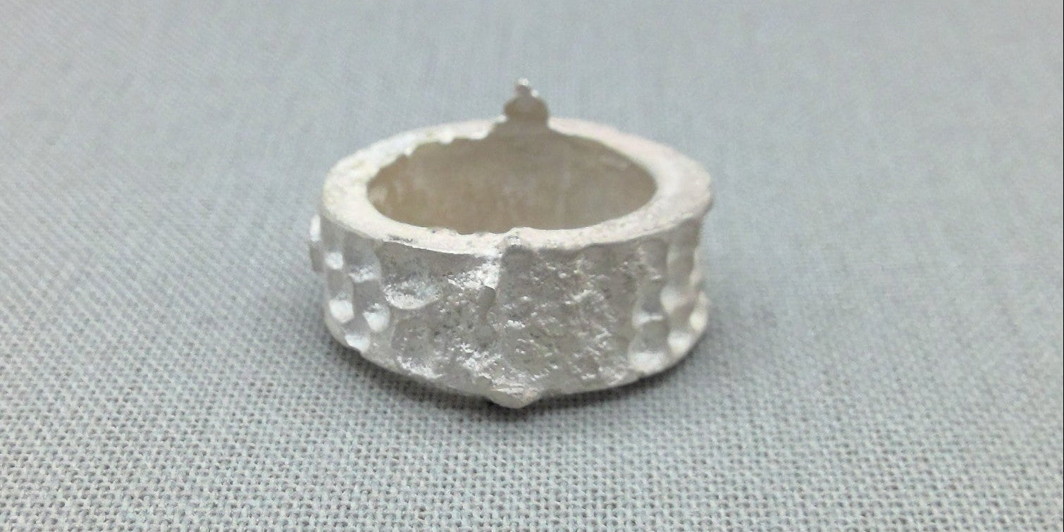 Textured silver ring, architectural relic design, close-up