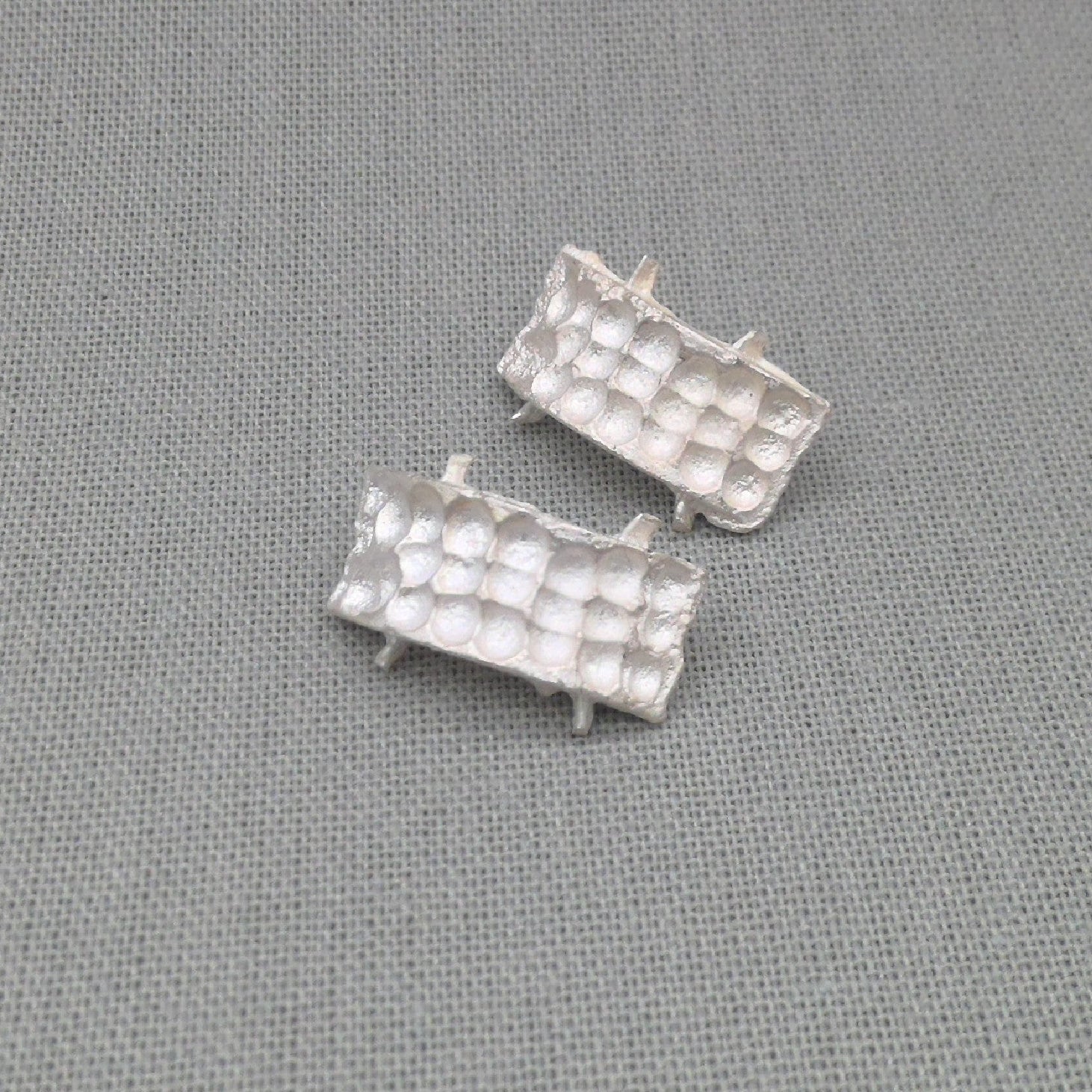 Textured white silver earrings, close-up detail