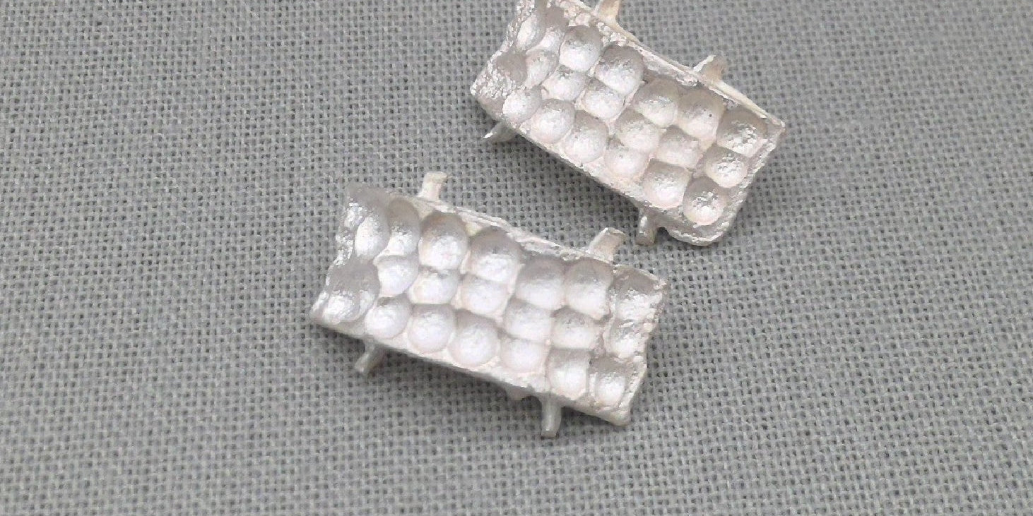 Textured white silver earrings, close-up detail