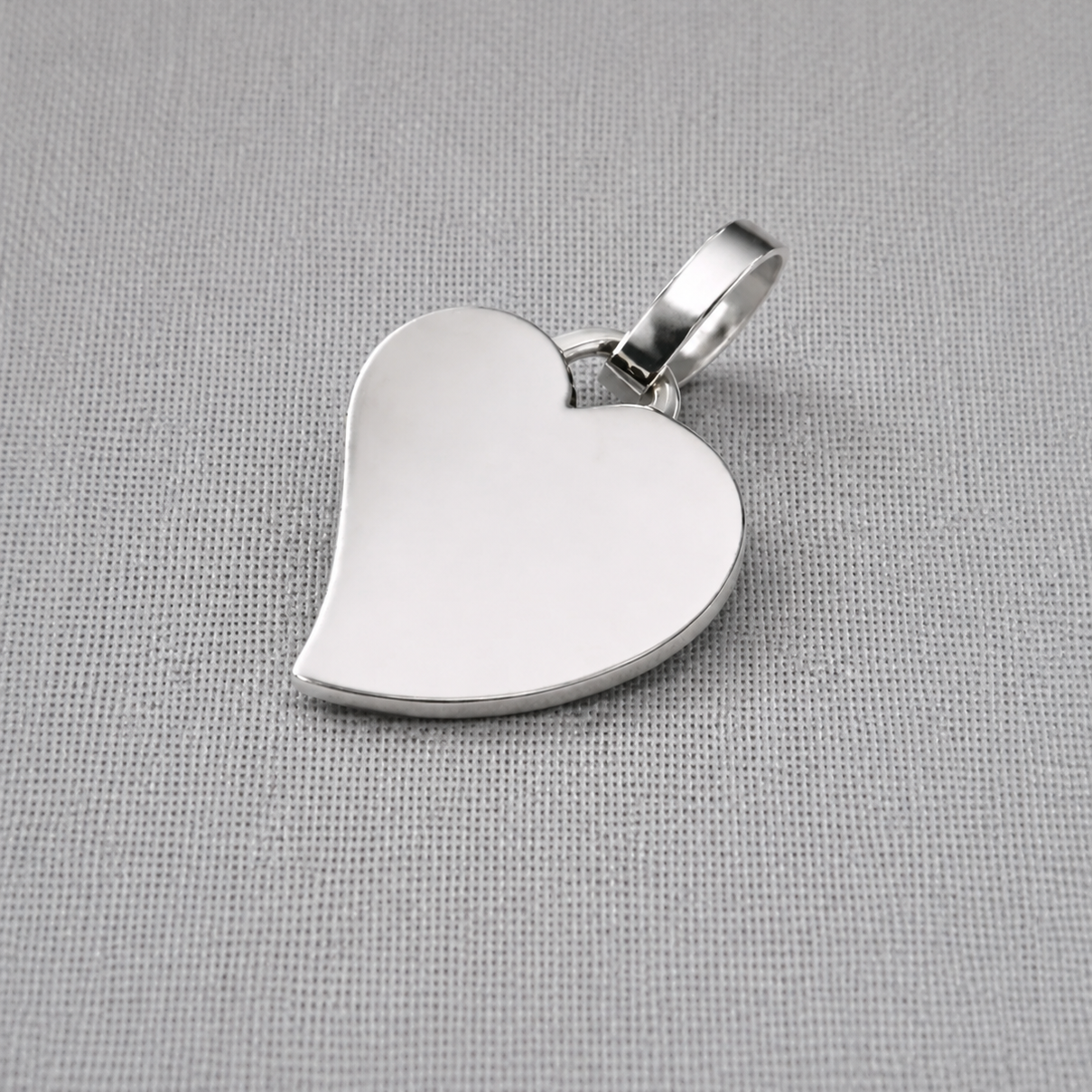 Personalised recycled silver heart pendant with polished finish on fabric