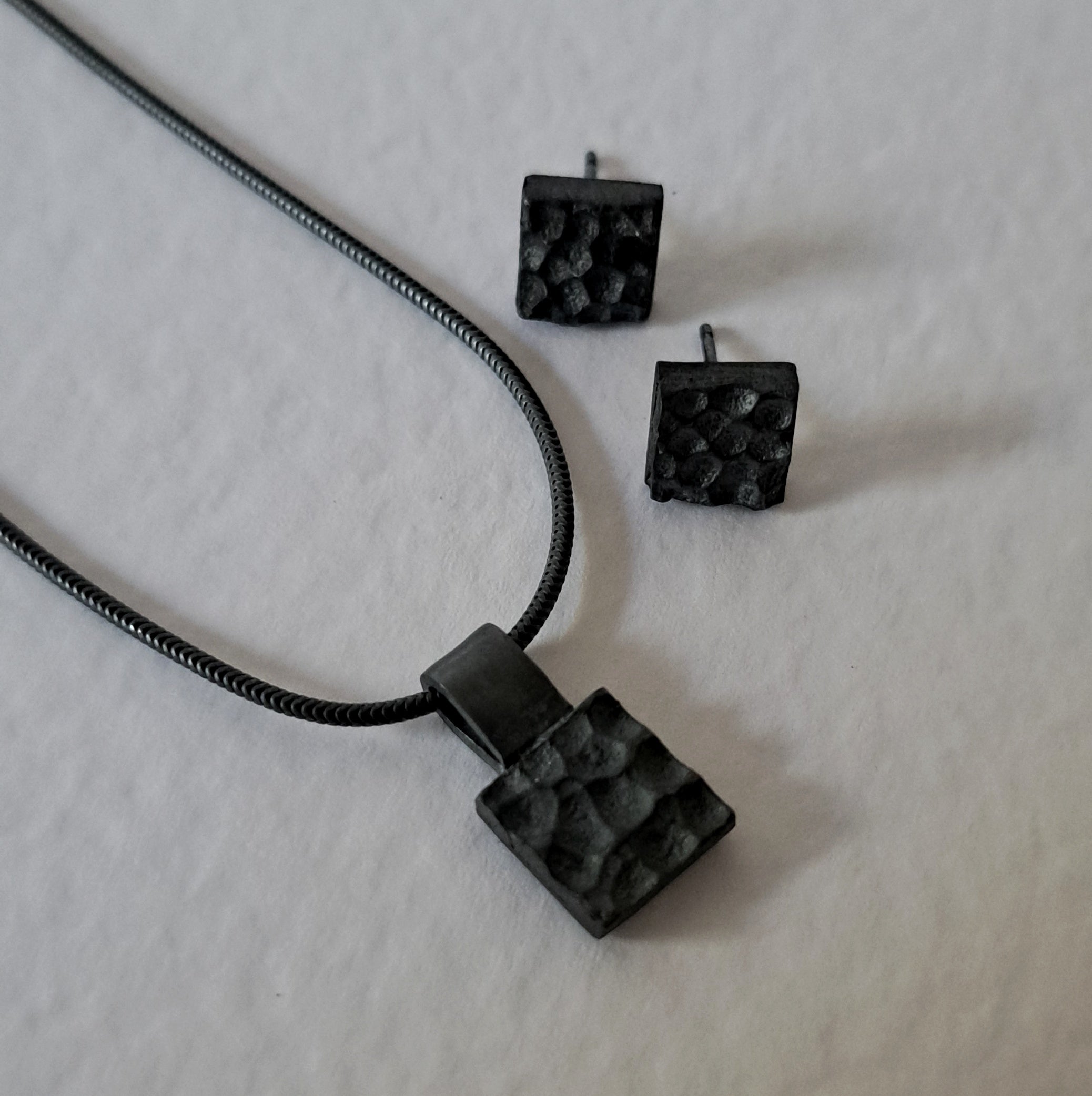 Handcrafted black oxidised sterling silver jewellery set featuring a sculptural pendant and matching stud earrings inspired by architecture and the SONYJA MINI Collection.