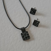 Handcrafted black oxidised sterling silver jewellery set featuring a sculptural pendant and matching stud earrings inspired by architecture and the SONYJA MINI Collection.