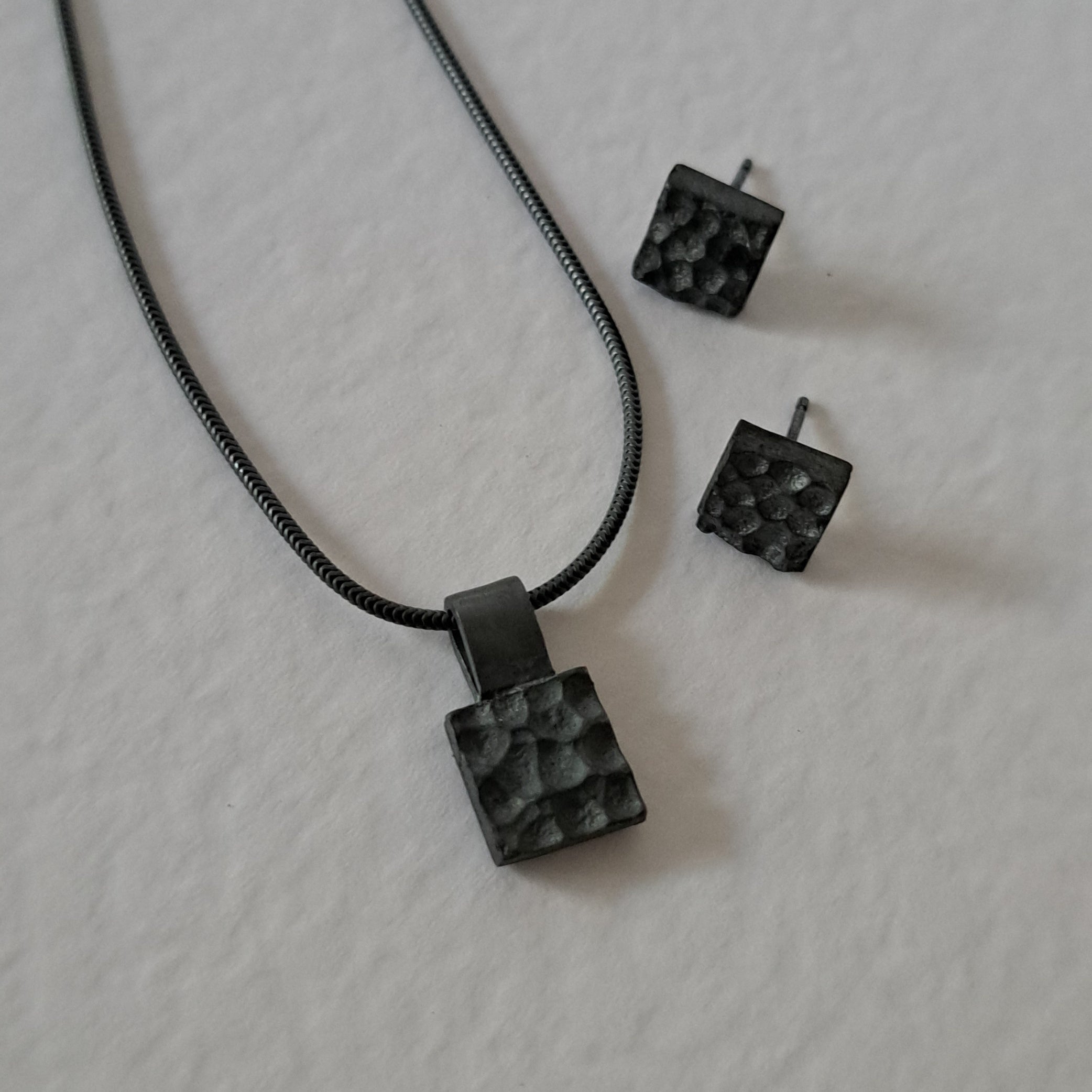 Handcrafted black oxidised sterling silver jewellery set featuring a sculptural pendant and matching stud earrings inspired by architecture and the SONYJA MINI Collection.