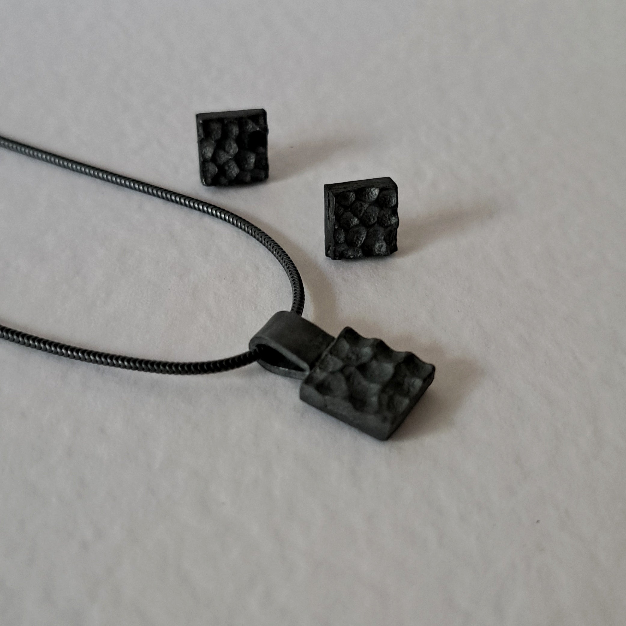 Handcrafted black oxidised sterling silver jewellery set featuring a sculptural pendant and matching stud earrings inspired by architecture and the SONYJA MINI Collection.
