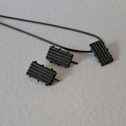 Handcrafted black oxidised sterling silver jewellery set featuring a sculptural pendant and matching stud earrings with a contemporary architectural design.