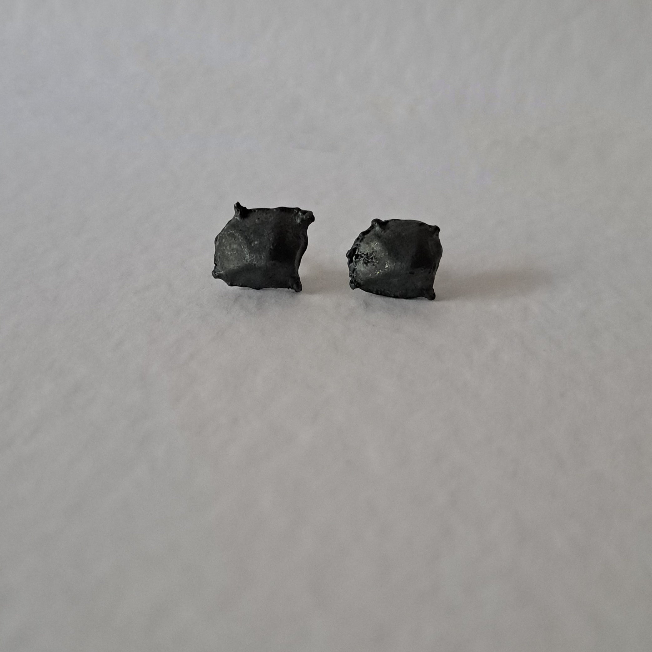 Handcrafted Futurist Brutalist Pebble Stud Earrings in black oxidised sterling silver featuring an organic sculptural texture inspired by architecture and natural stone.