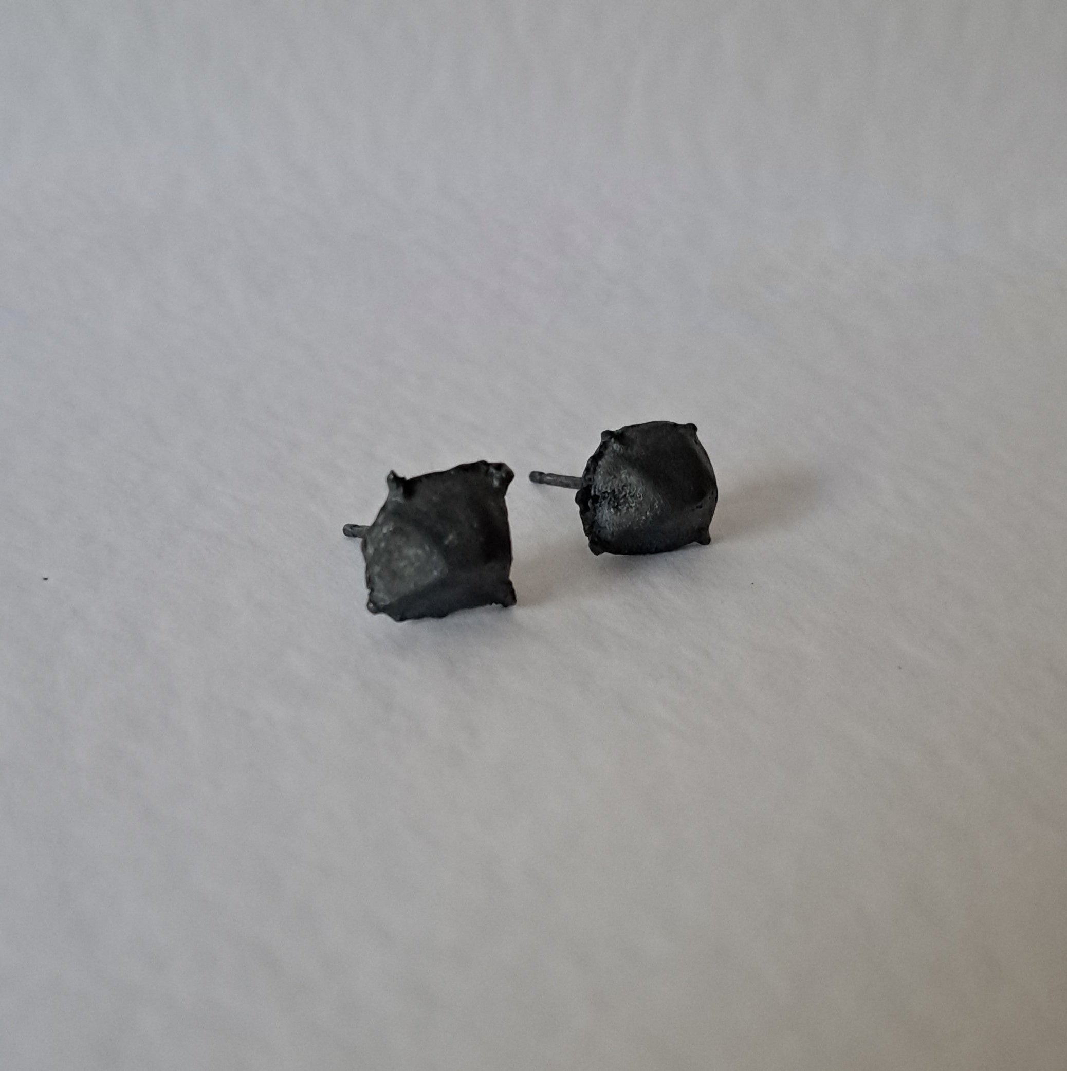 Handcrafted Futurist Brutalist Pebble Stud Earrings in black oxidised sterling silver featuring an organic sculptural texture inspired by architecture and natural stone.