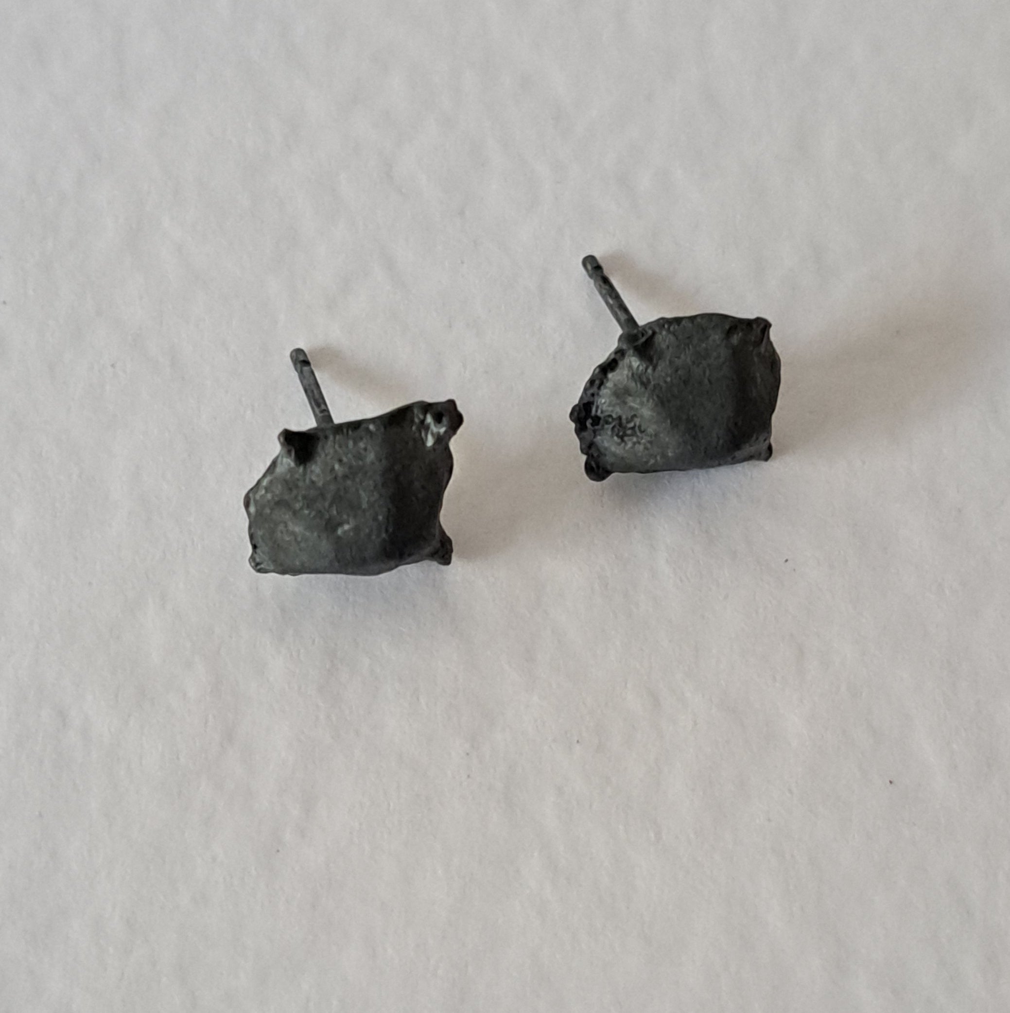 Handcrafted Futurist Brutalist Pebble Stud Earrings in black oxidised sterling silver featuring an organic sculptural texture inspired by architecture and natural stone.