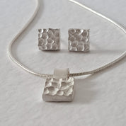 Handcrafted MINI sterling silver jewellery set featuring a sculptural textured pendant on a snake chain with matching stud earrings inspired by architecture.