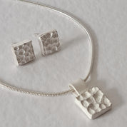 Handcrafted MINI sterling silver jewellery set featuring a sculptural textured pendant on a snake chain with matching stud earrings inspired by architecture.