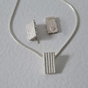 Handcrafted MINI sterling silver jewellery set featuring a sculptural pendant and matching stud earrings with an architectural linear texture.