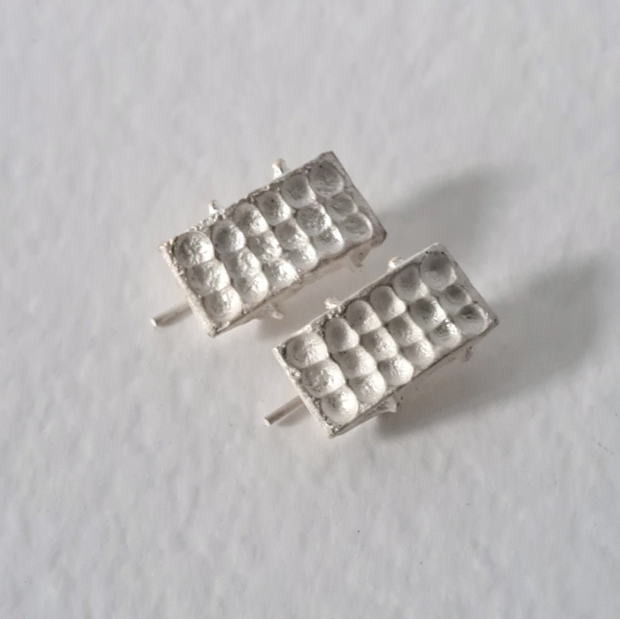 Handcrafted sculptural sterling silver stud earrings from the SONYJA MINI Collection with textured geometric design.
