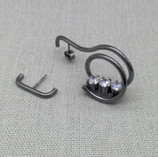 Asymmetrical oxidized recycled silver earrings with zircon stones on fabric