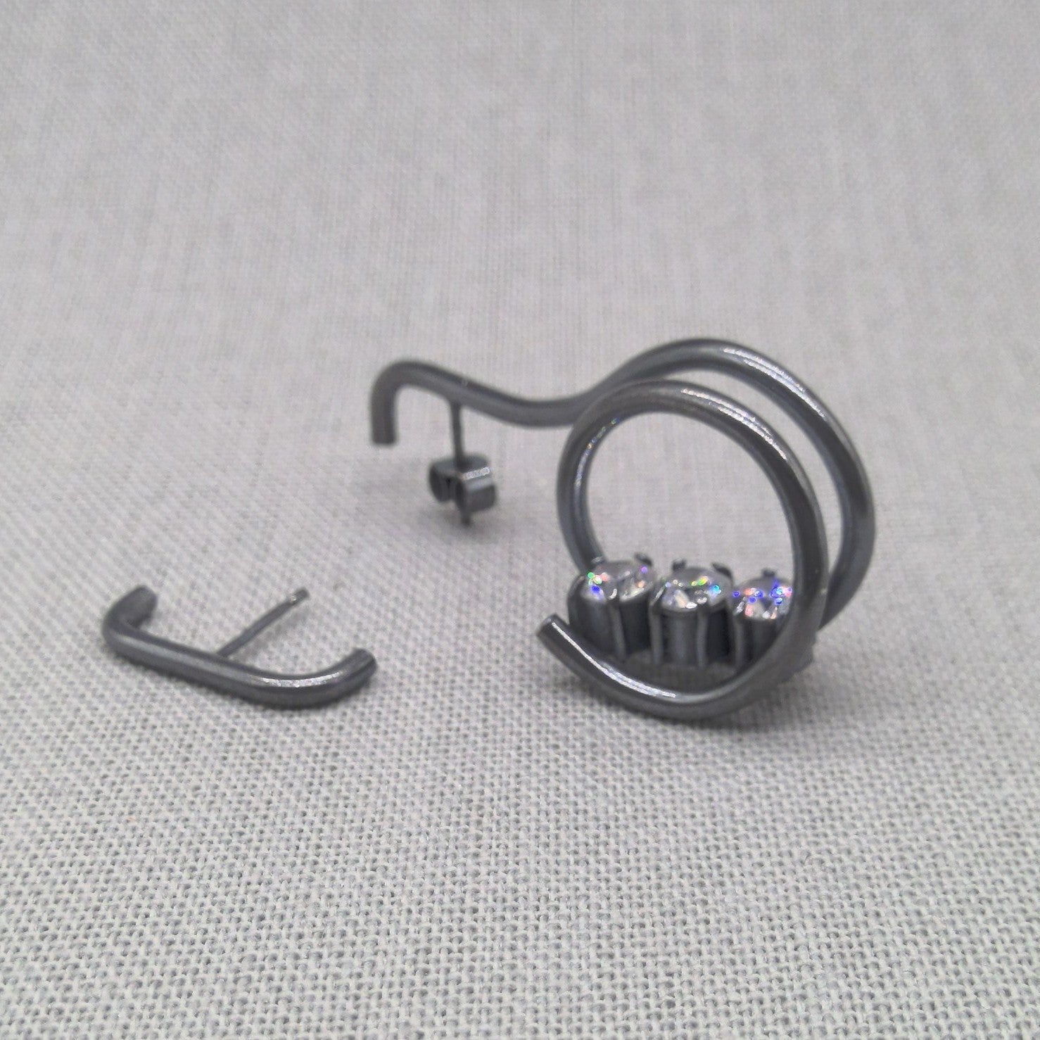 Side detail shot of asymmetrical recycled silver zircon earrings