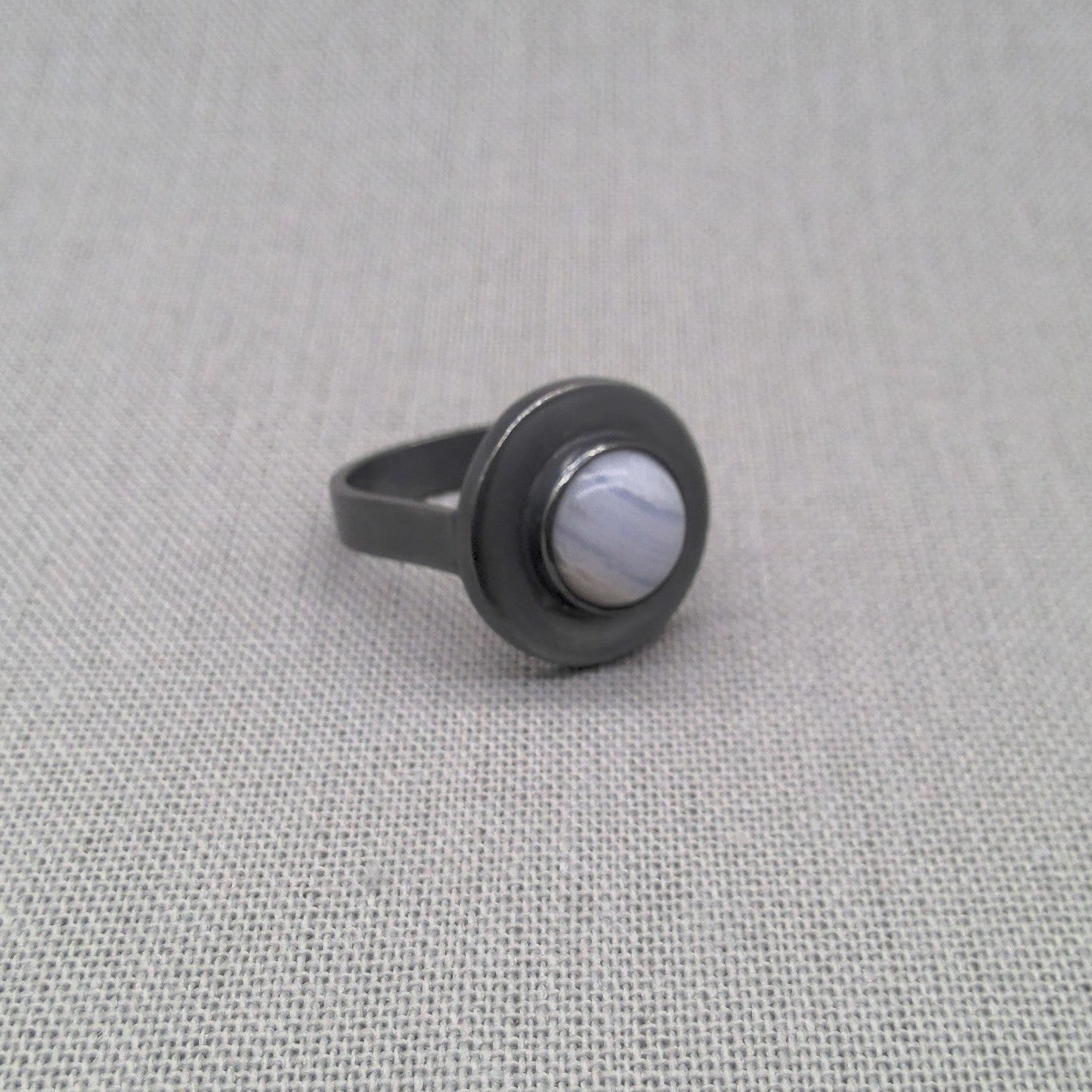 Top-down view of blue lace agate cabochon in silver setting
