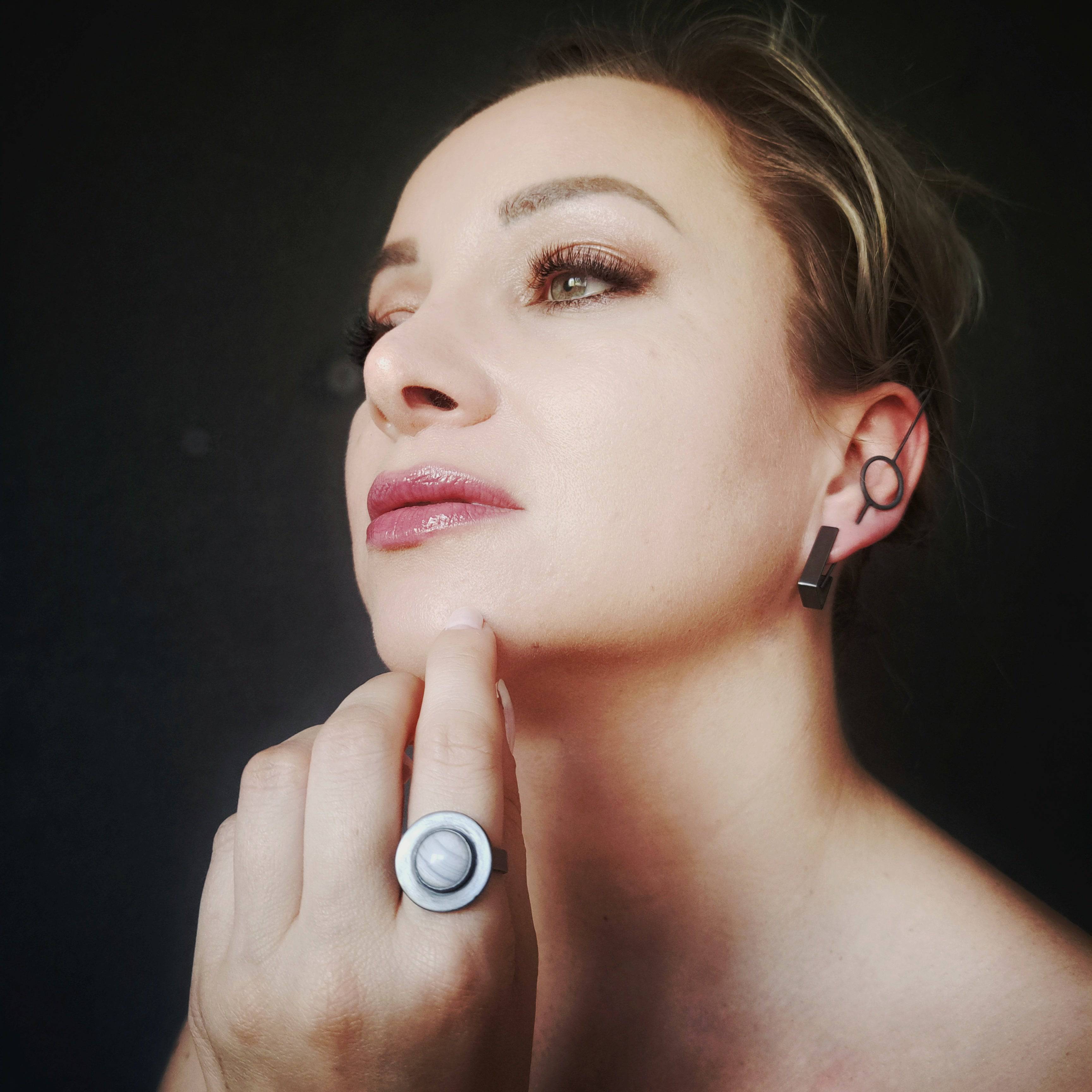 Model wearing blue lace agate silver ring near face