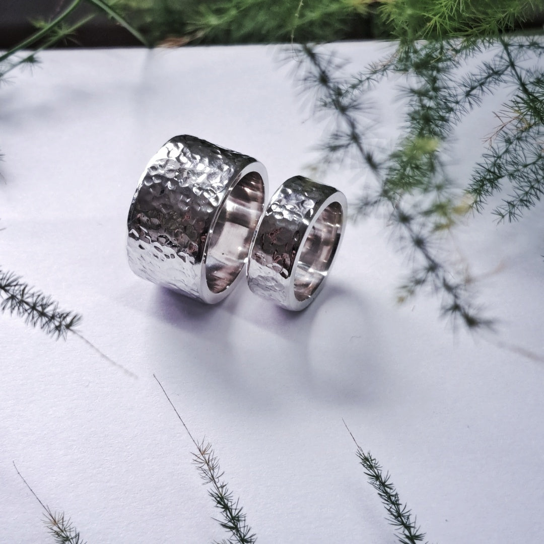 Close-up pair of chunky hammered recycled silver wedding rings