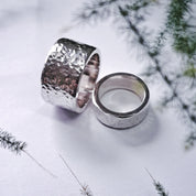 Angled view of stacked hammered silver wedding rings