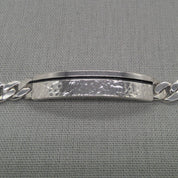 Angled view of recycled silver ID bracelet plaque and chain detail