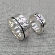 Chunky hammered recycled silver wedding ring set with dark inlay on fabric
