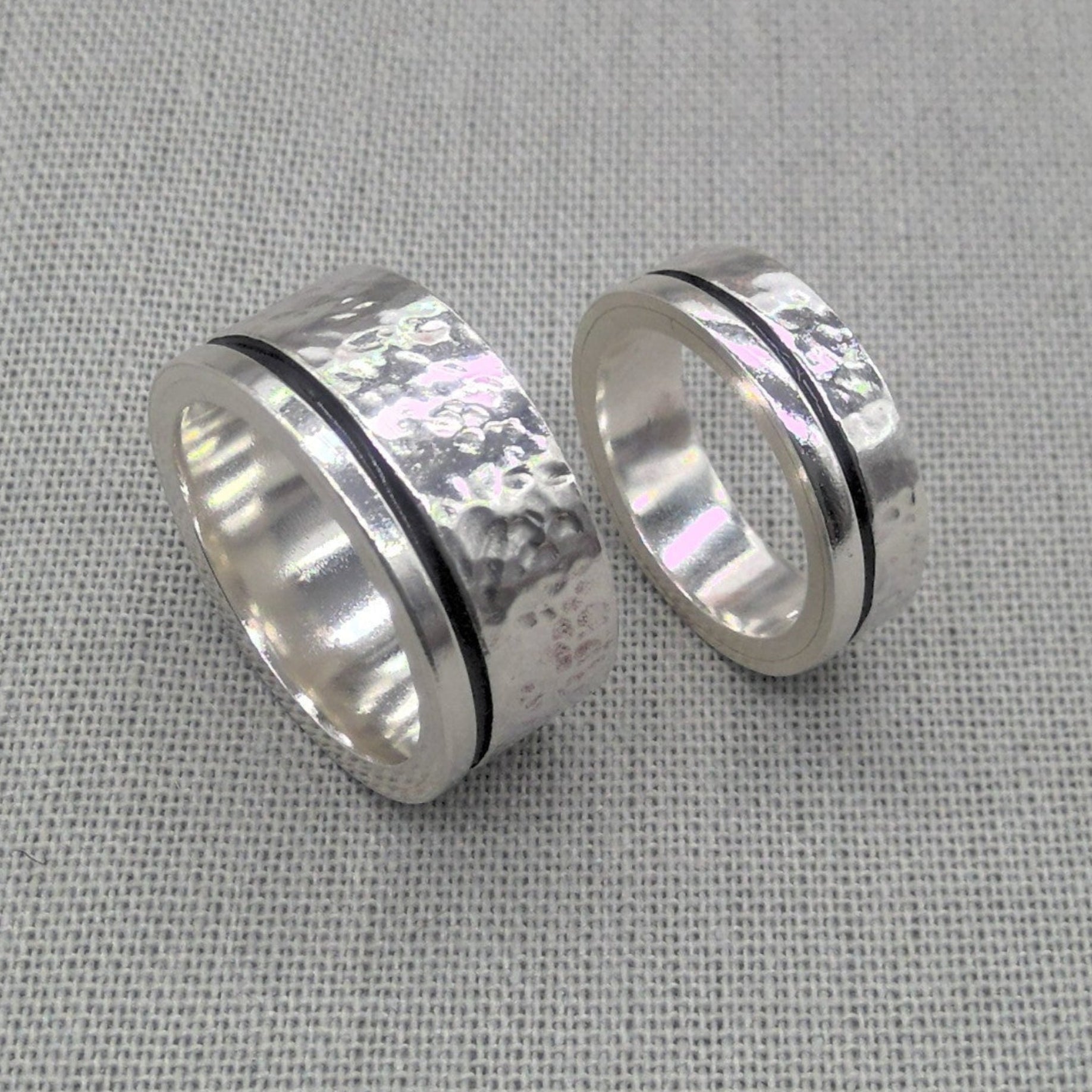 Chunky hammered recycled silver wedding ring set with dark inlay on fabric