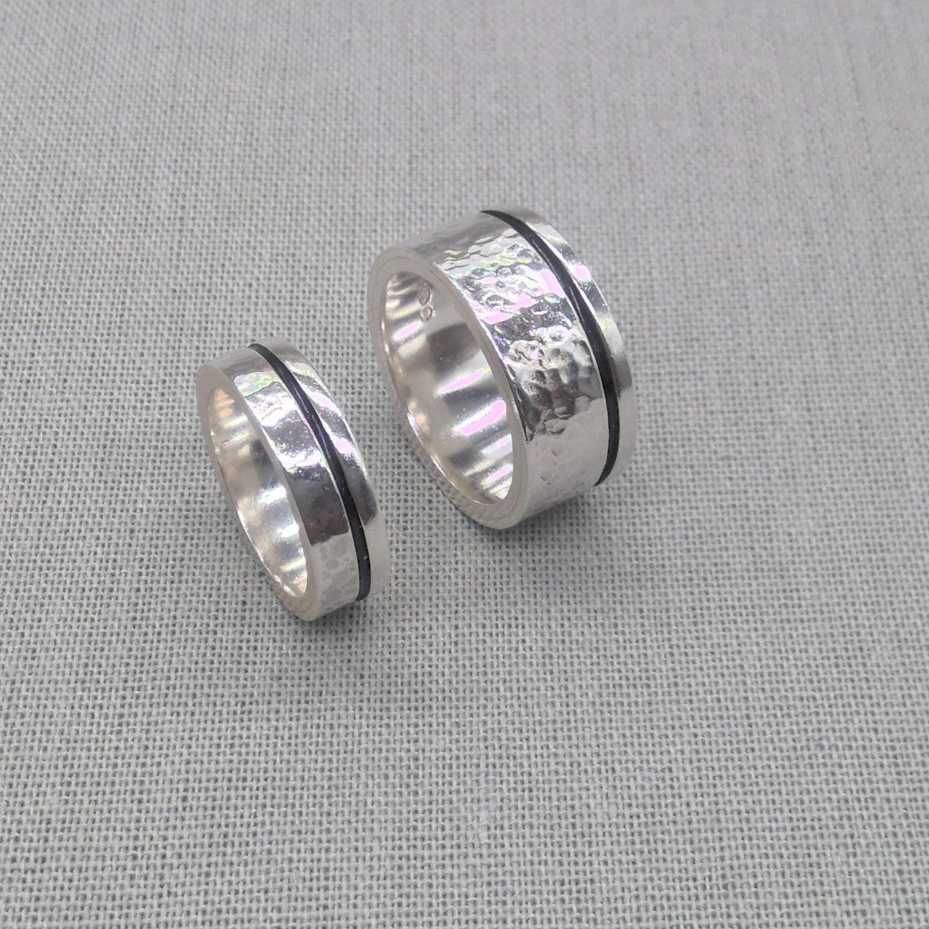 Side view of two chunky recycled silver wedding rings with hammered texture