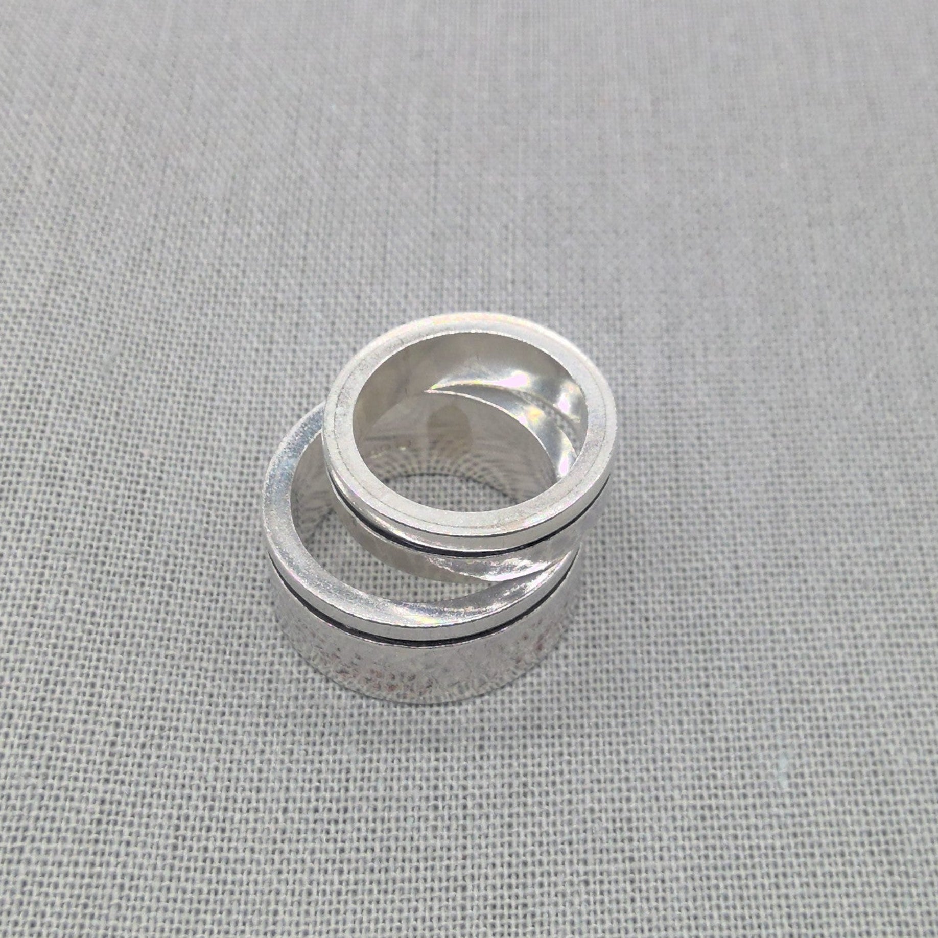Top-down view of stacked chunky recycled silver wedding rings