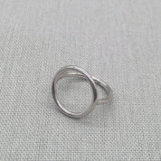 Angled view of polished silver sculptural circle ring