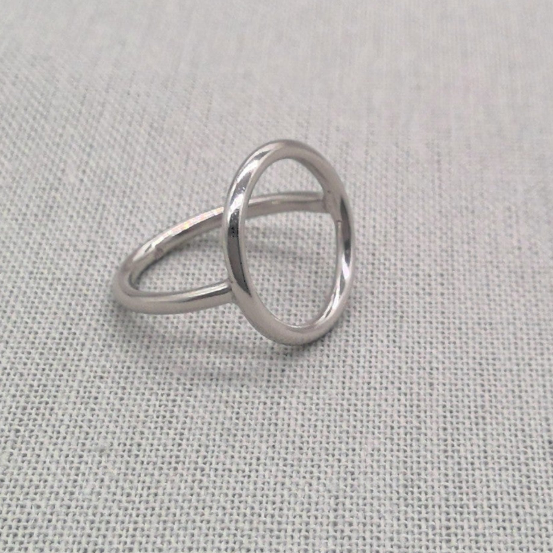 Side profile of polished silver circle ring showing geometric shape