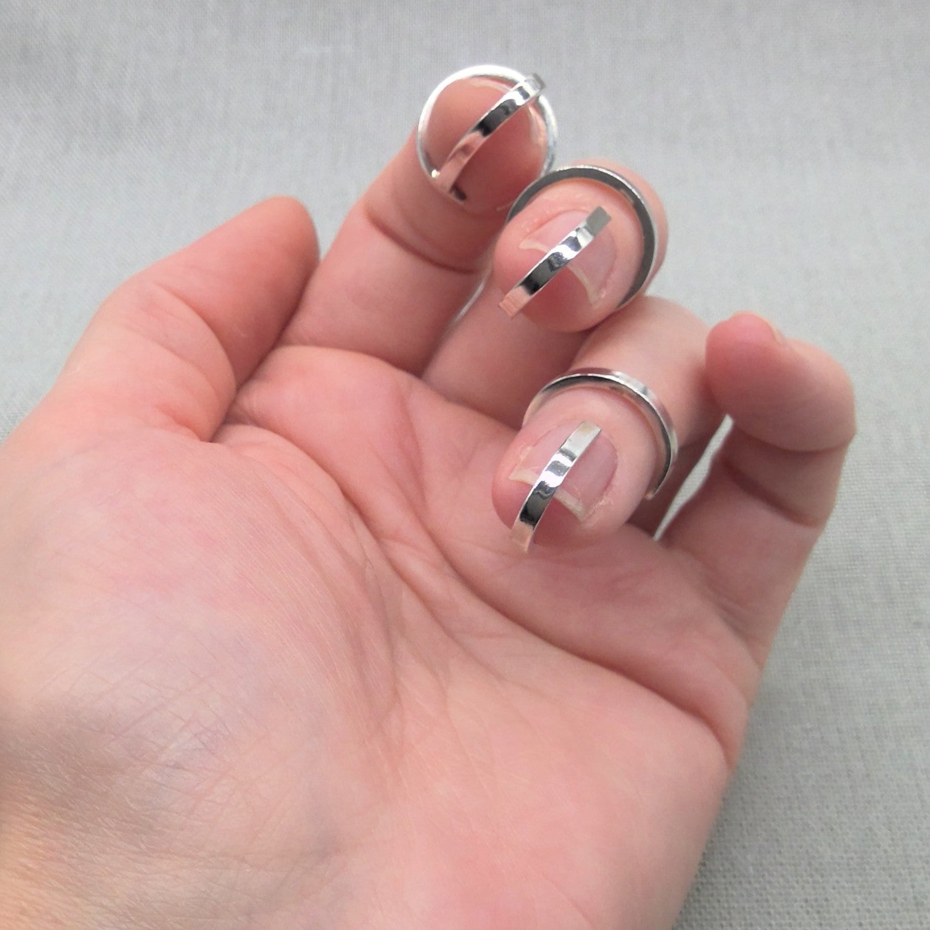 Close-up of Gladiator silver wrap rings in open palm