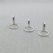 Three silver wrap rings from Gladiator collection laid flat on fabric