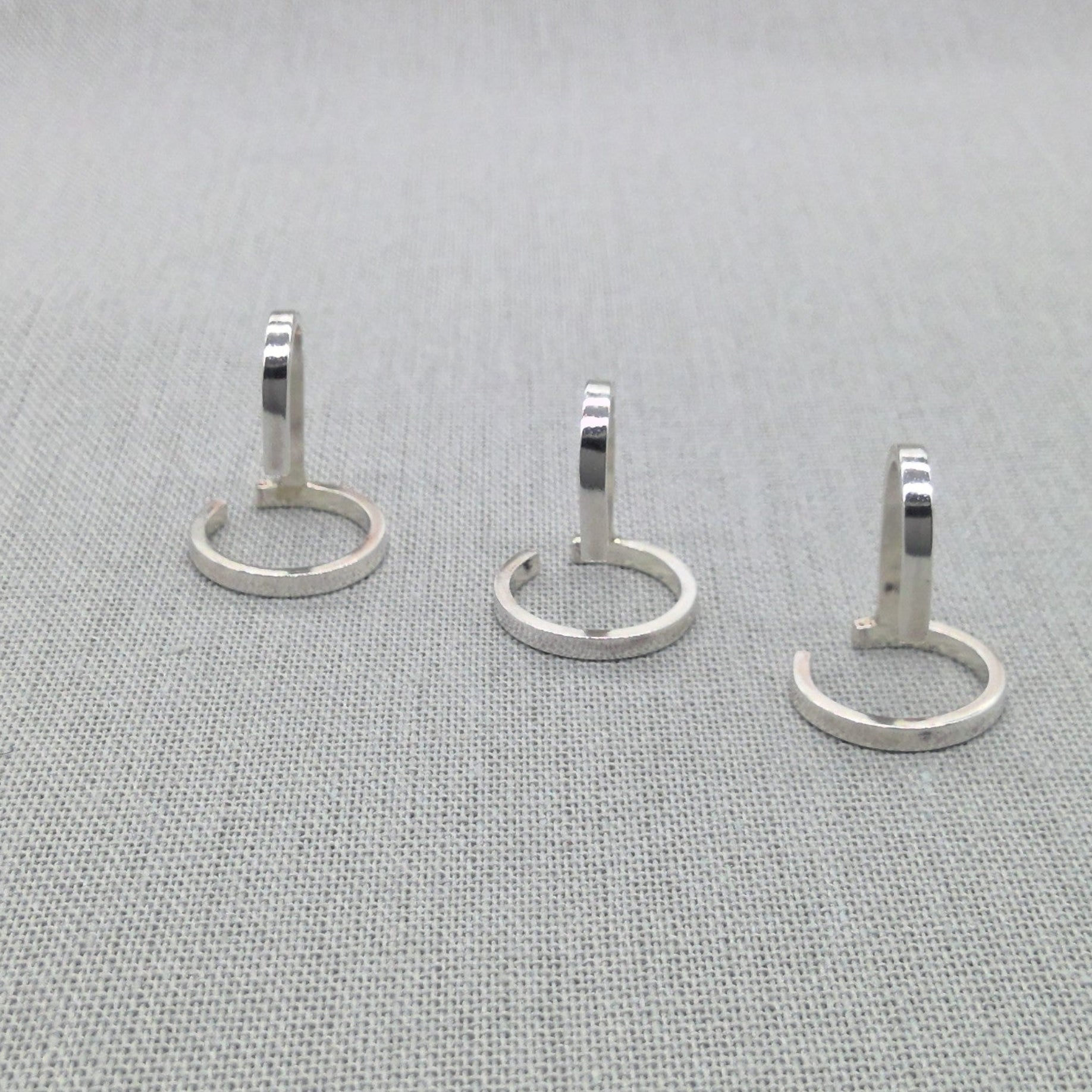 Three silver wrap rings from Gladiator collection laid flat on fabric