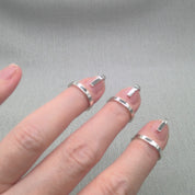 Close-up of fingers wearing Gladiator recycled silver wrap rings