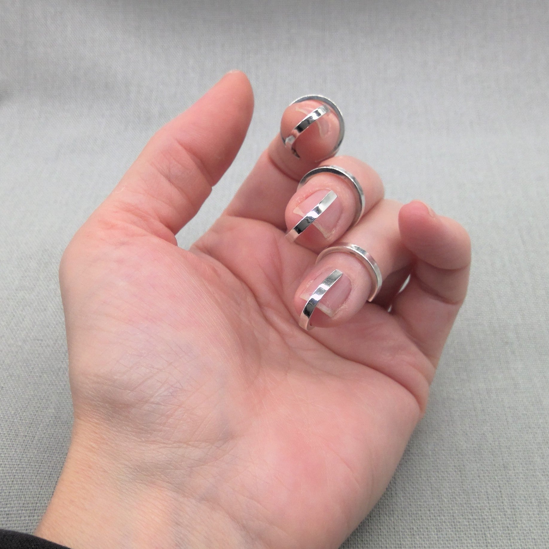 Side view of hand wearing Gladiator collection silver rings