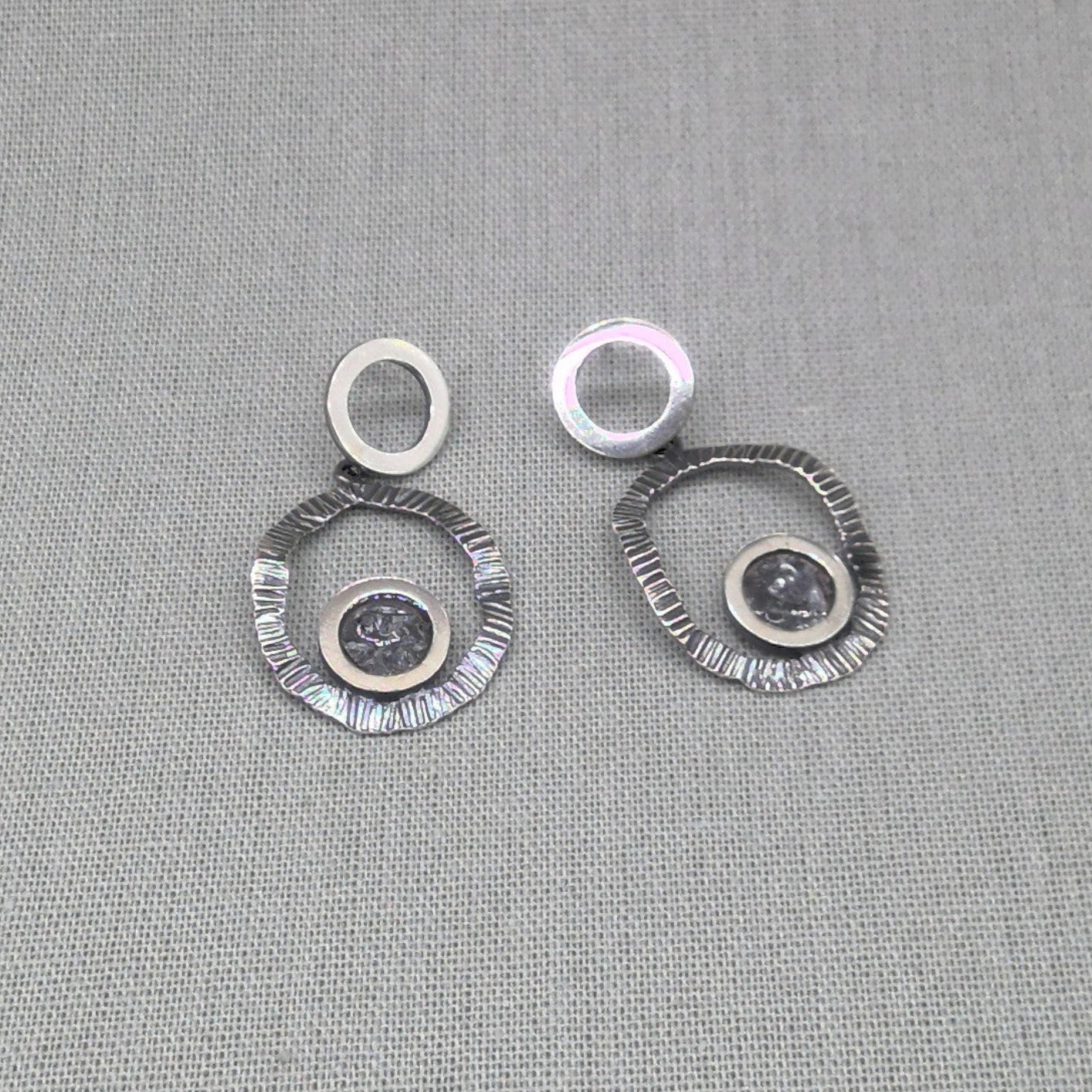 Angled view of double circle recycled silver zircon earrings