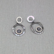 Angled view of double circle recycled silver zircon earrings