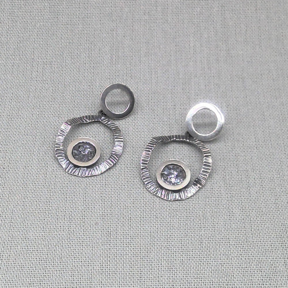 Close-up of zircon and resin centre on hammered silver earring