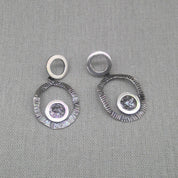 Front view of hammered silver circle earrings with zircon detail