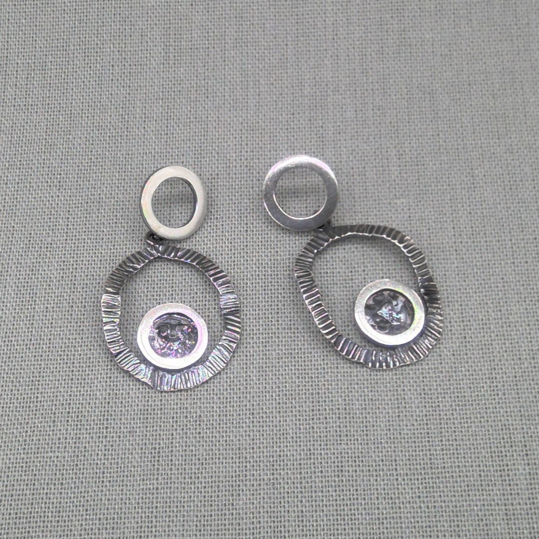 Front view of hammered silver circle earrings with zircon detail