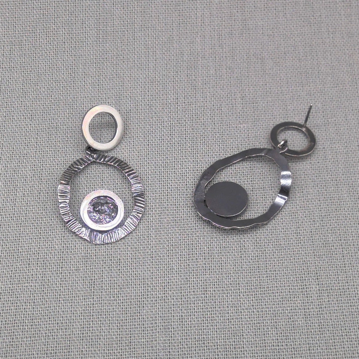 Side detail of hammered silver earring showing hook and circles