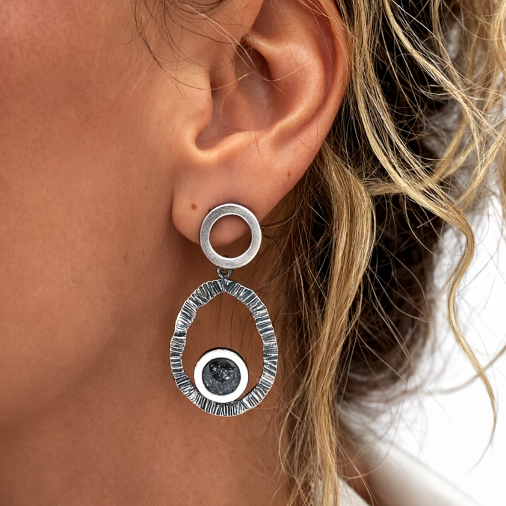 Close-up of model wearing hammered zircon earring on ear