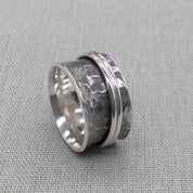 Hammered recycled silver spinner ring with rotating band on fabric