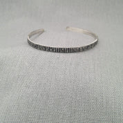 Close-up of hammered texture detail on recycled silver cuff bangle