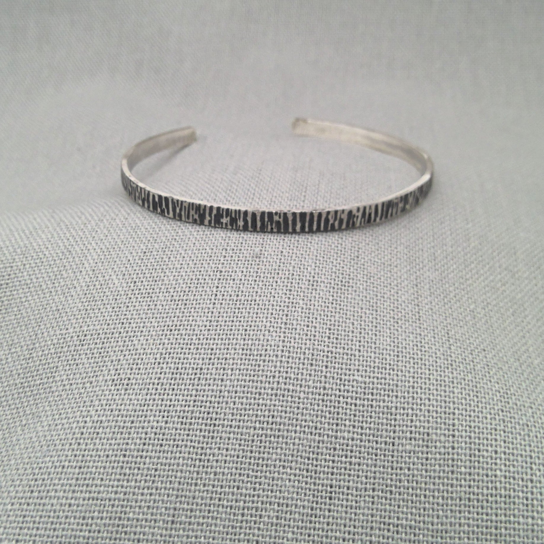 Close-up of hammered texture detail on recycled silver cuff bangle