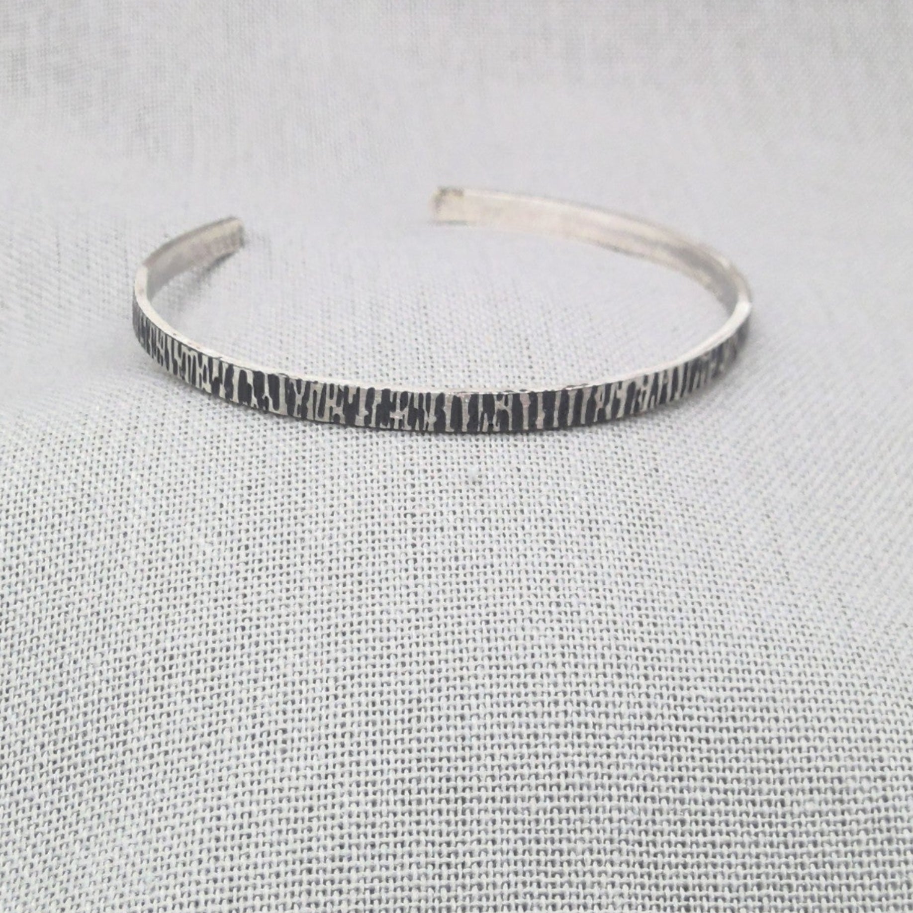 Front view of open hammered silver cuff bangle