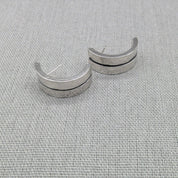 Front view of hammered silver ear cuffs showing open design