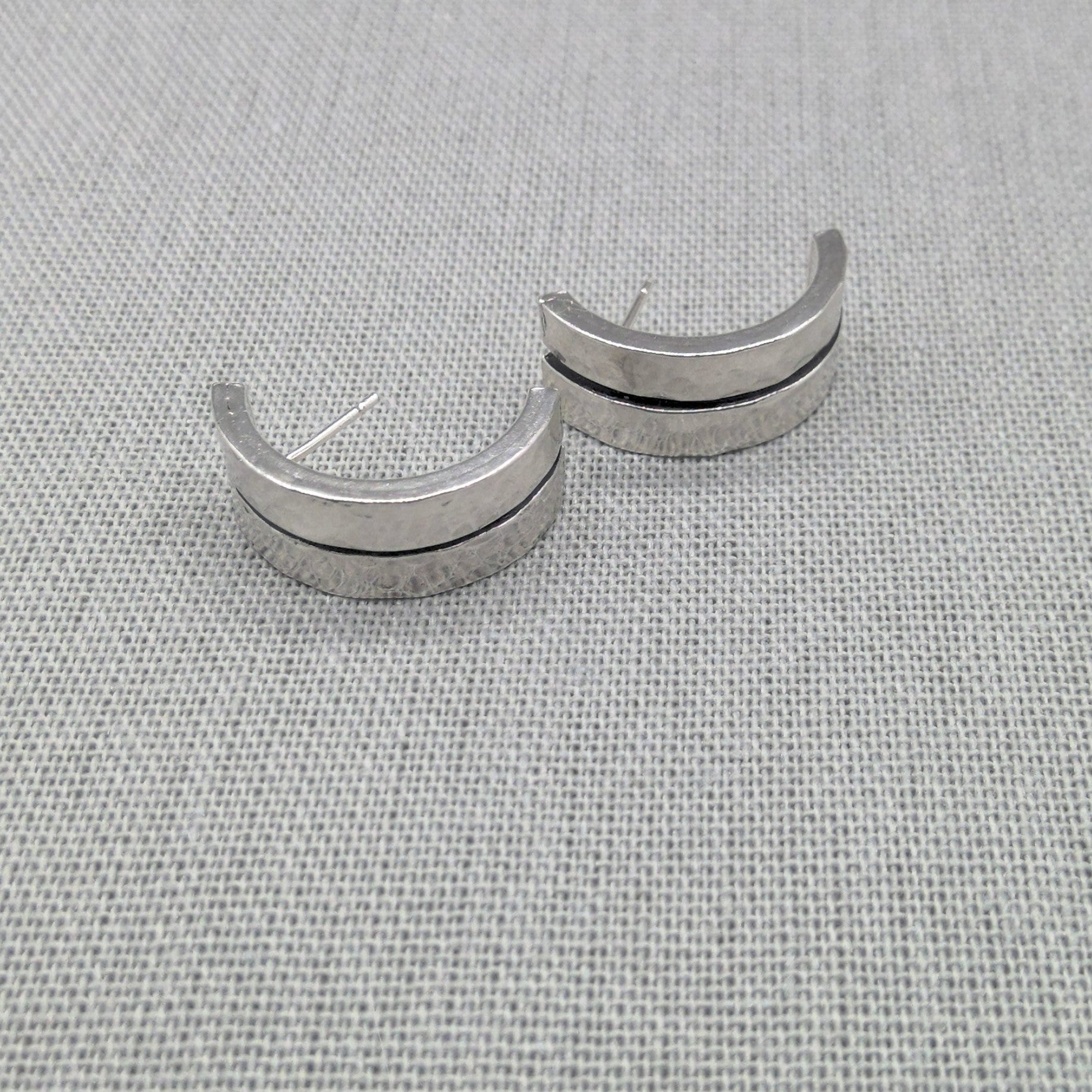 Front view of hammered silver ear cuffs showing open design