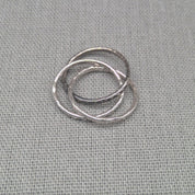 Angled view of three interlocking recycled silver ring bands