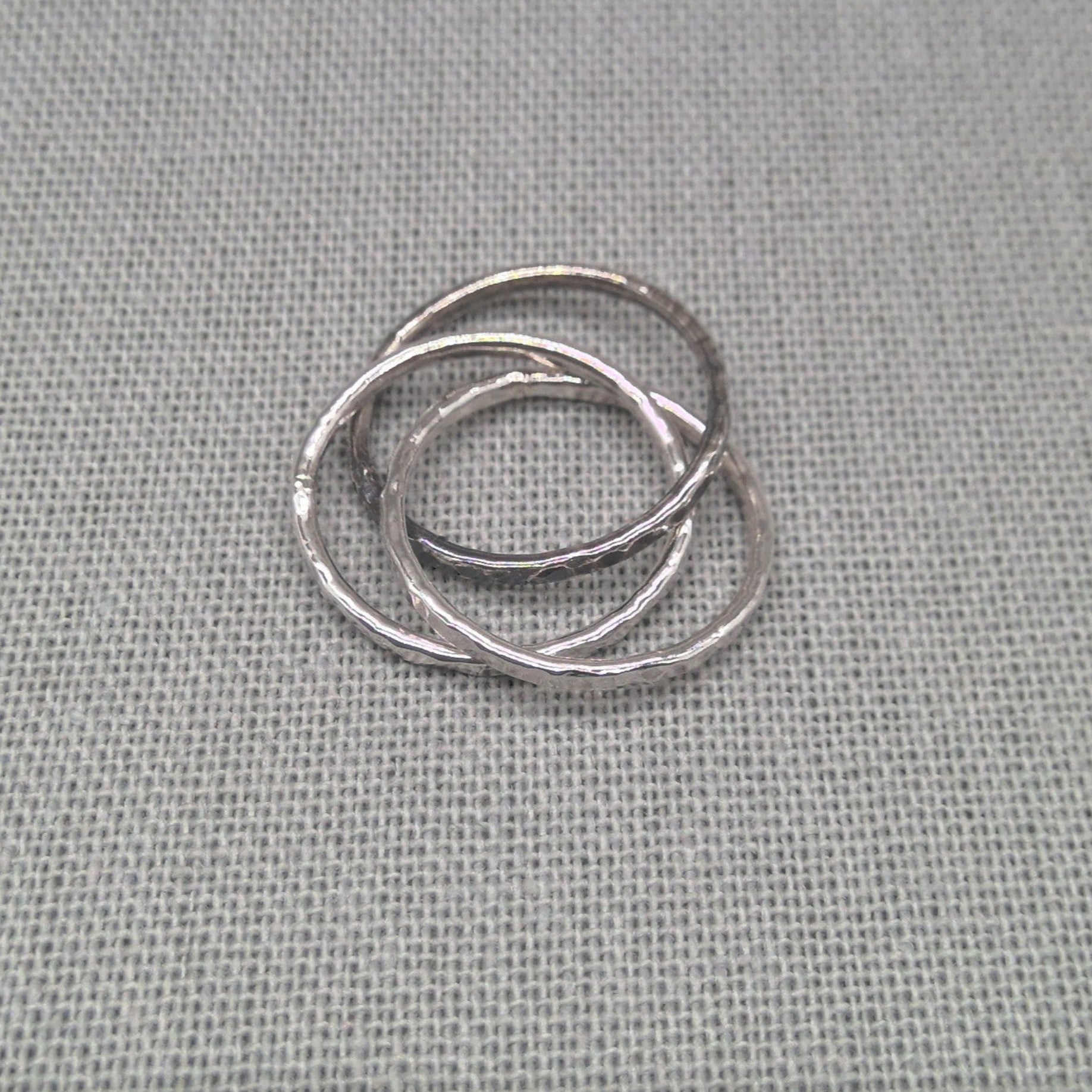 Angled view of three interlocking recycled silver ring bands