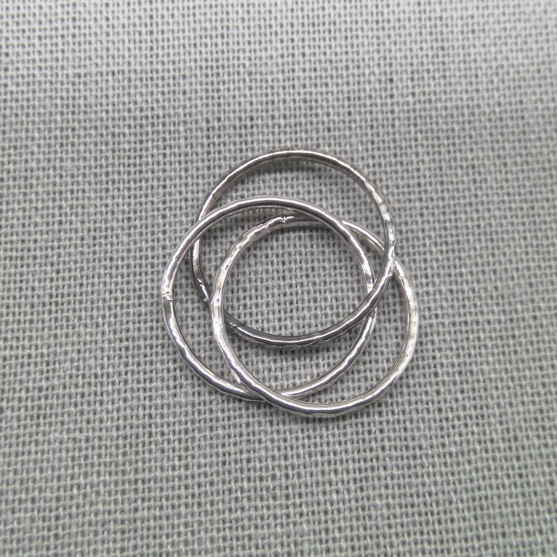 Top-down view of interlocking hammered silver ring bands